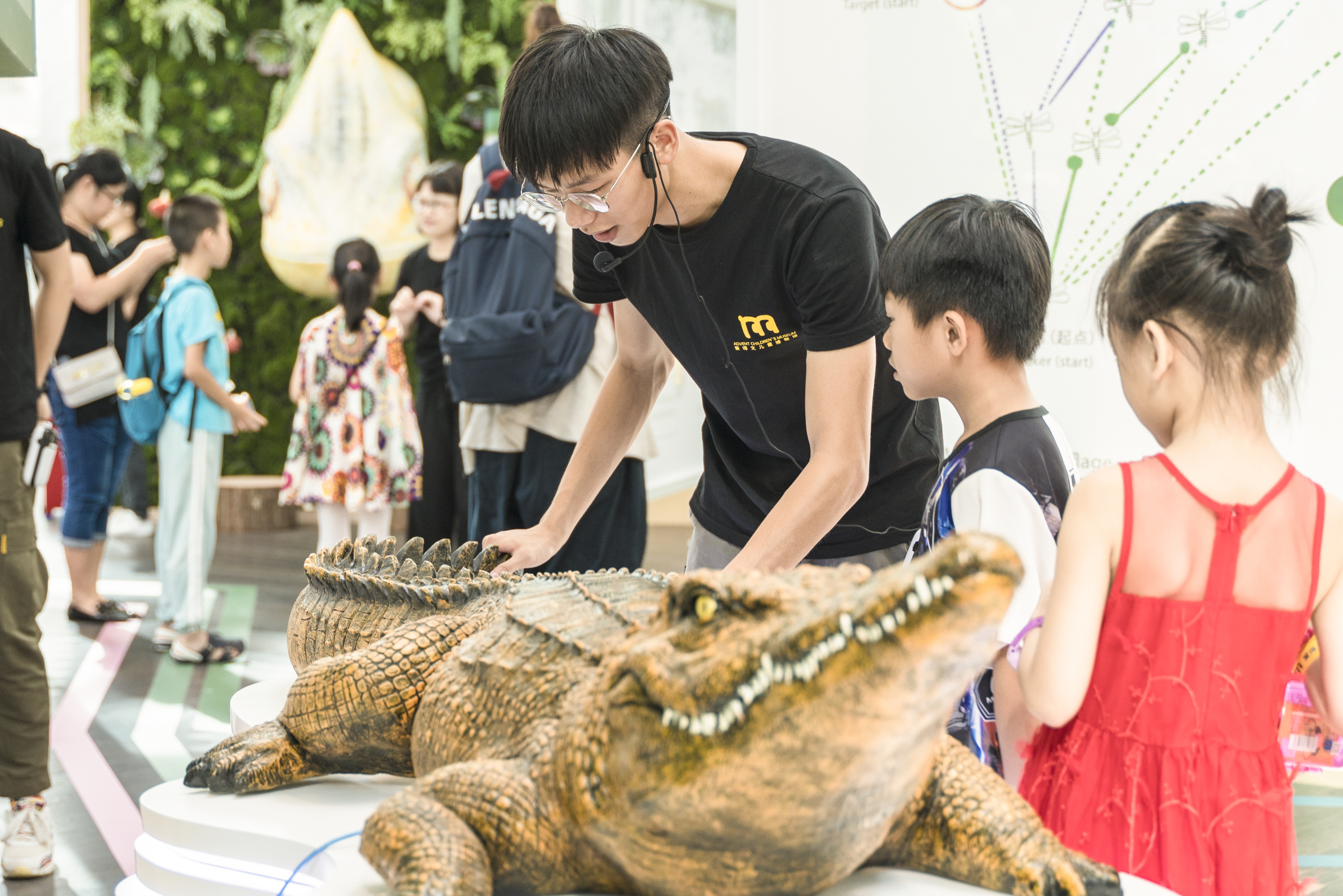 展览引导员向小朋友们介绍鳄鱼神奇的身体构造
